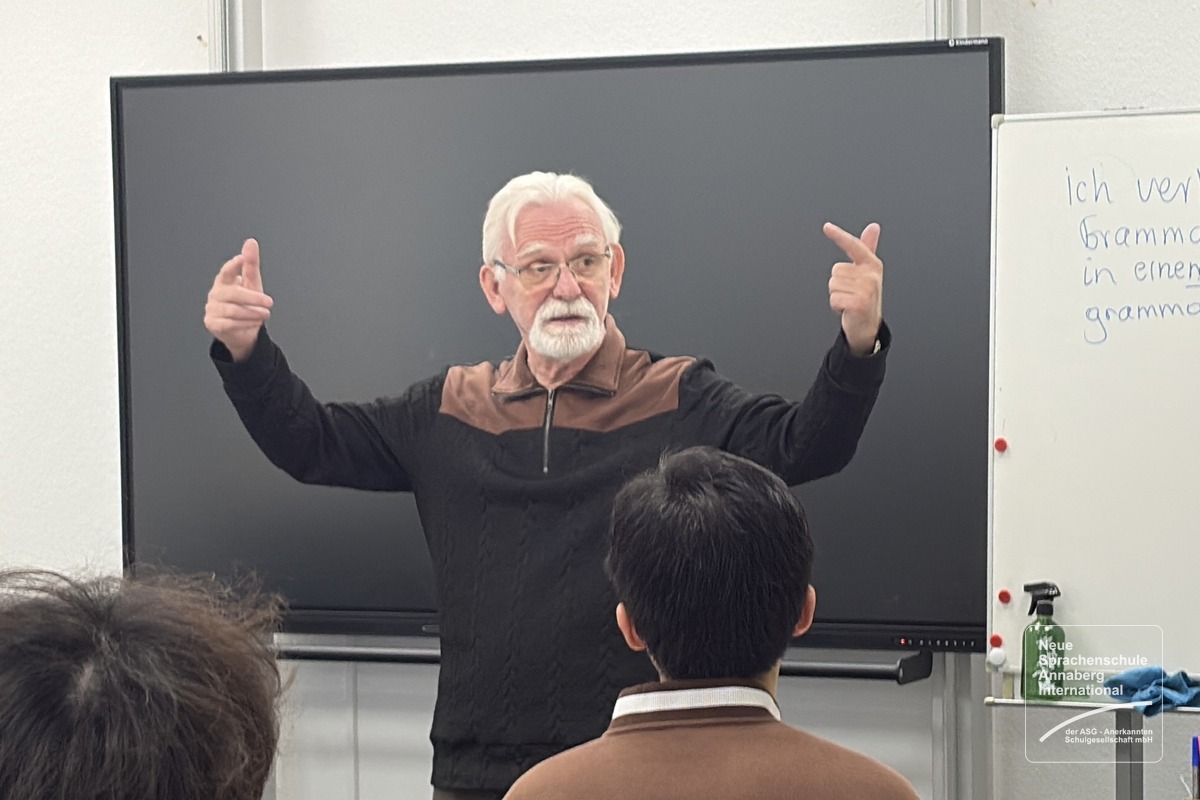 Bernd Barthel zeigt mit lebhaften Handbewegungen eine Übung vor seiner Klasse